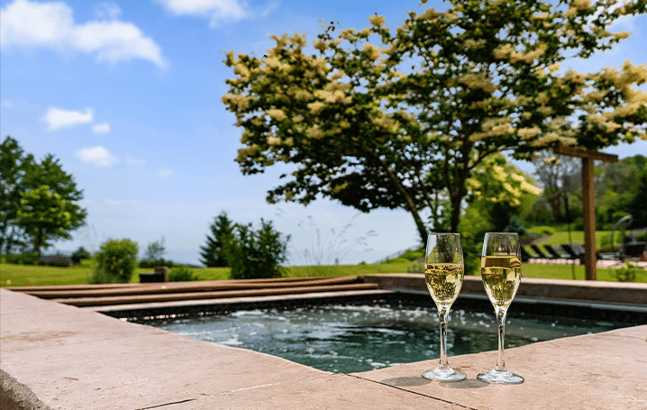 Hot tub at Mansion on the Lake with two champagne glasses, offering a luxurious lakeside relaxation experience