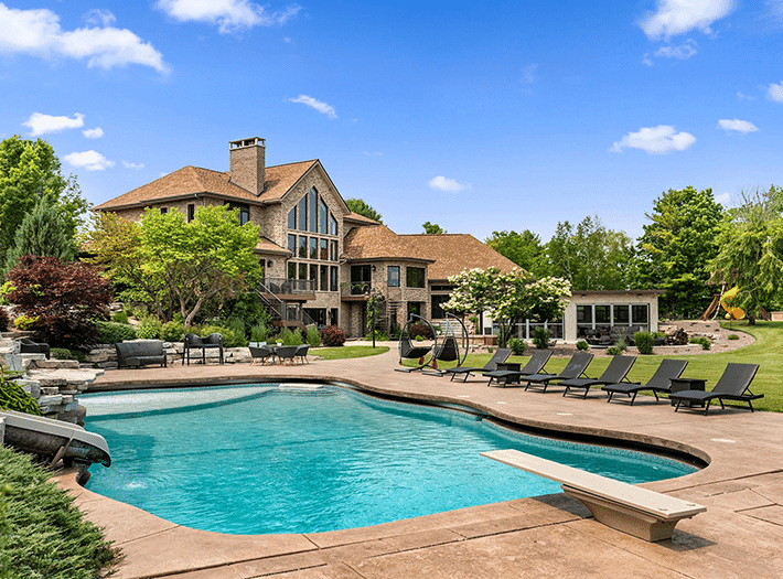 Outdoor pool with diving board at Mansion on the Lake with the house in the background