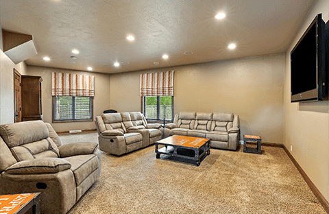 Family room with toys, games, ample seating, and large TV at Mansion on the Lake in Newton, WI, showing a view from two windows at a unique angle