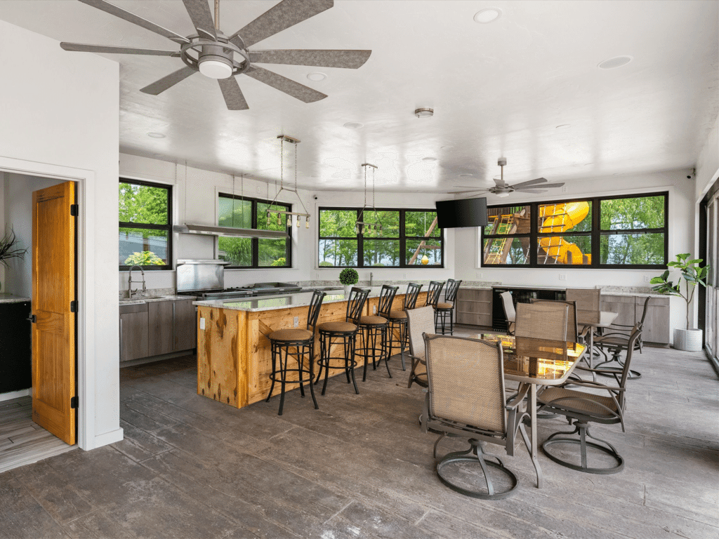 Outdoor pool room with kitchen and entertainment space at luxury vacation rental mansion on the lake near Newton, WI