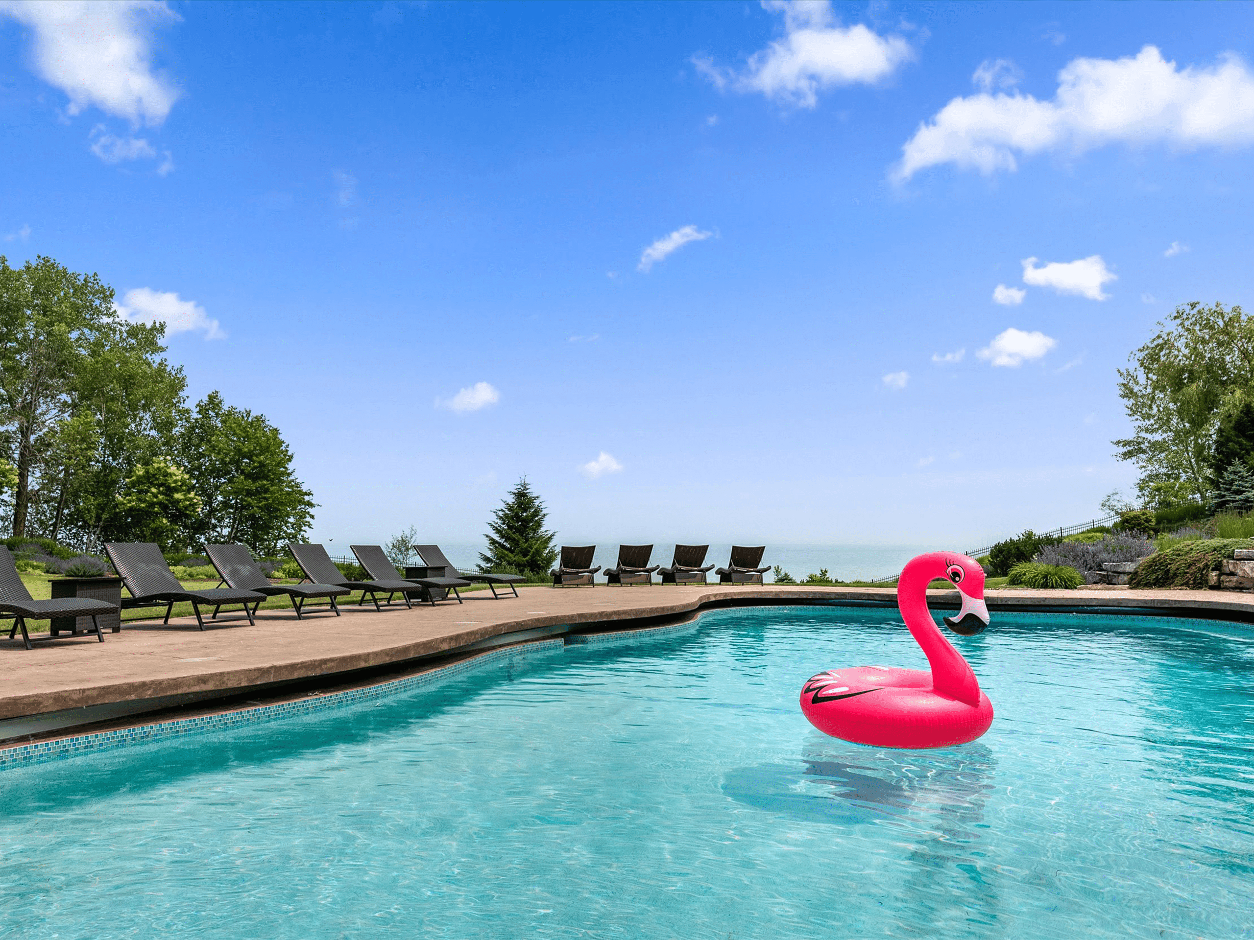 Pink flamingo float in outdoor pool at luxury vacation rental mansion on the lake near Newton, WI