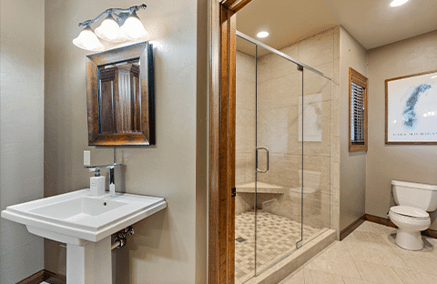 Upstairs main bathroom with dual showers, natural light, and luxury amenities at Mansion on the Lake in Newton, WI