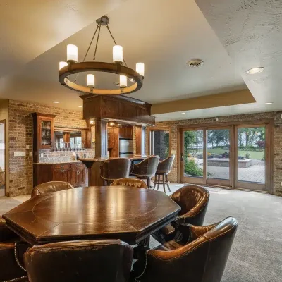 Downstairs game area at Mansion on the Lake with view of patio doors leading to outdoor pool, hot tub, and Lake Michigan
