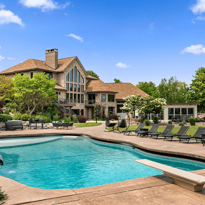 Outdoor pool with diving board at Mansion on the Lake with the house in the background